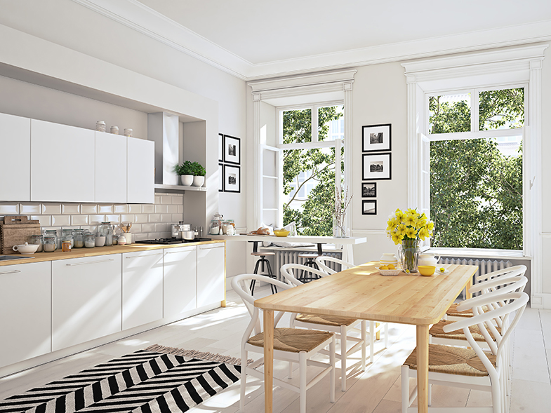 Modern kitchen with two large windows overlooking green trees